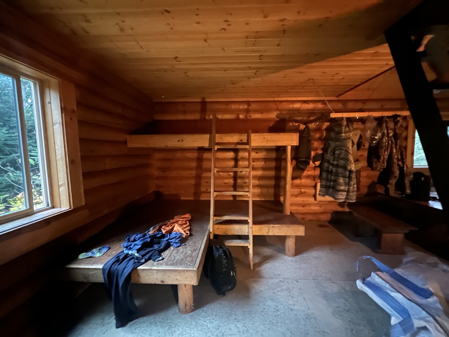 Wooden bunks and hooks with jackets in the cabin