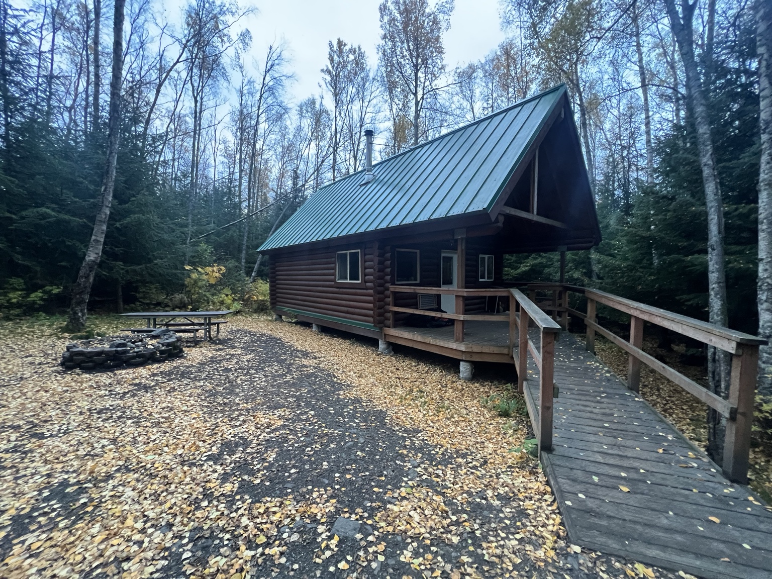 Log exterior of Bore Tide Cabin with green roof and wooden access ramp in October