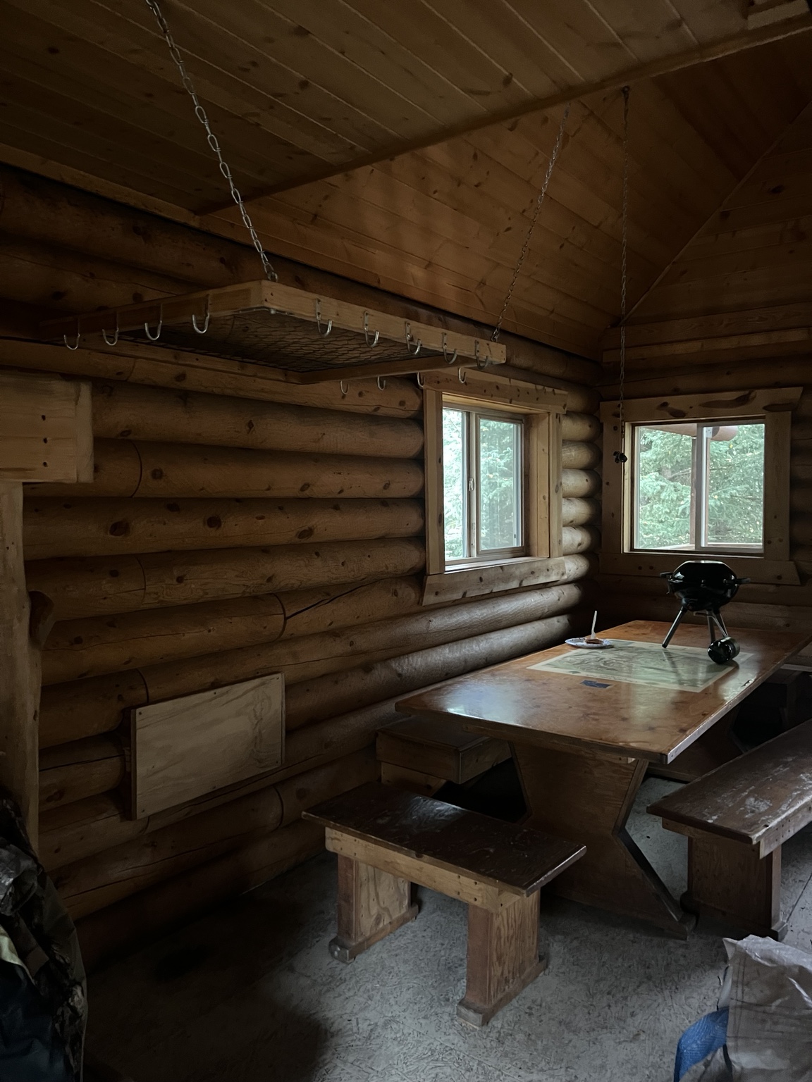 Wooden hanging storage shelf and hooks above the cabin dining table