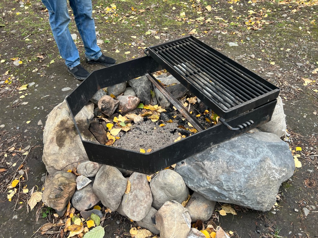 Black Bear Cabin fire ring with a swing-out grill grate